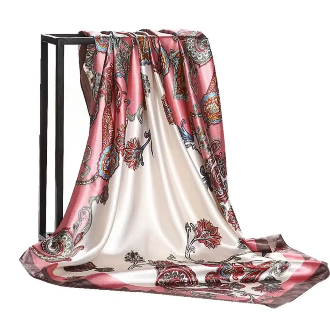 Decorative scarf with floral pattern draped over a black stand on a white background