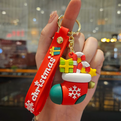 Hand holding a Christmas-themed keychain with a blurred indoor background