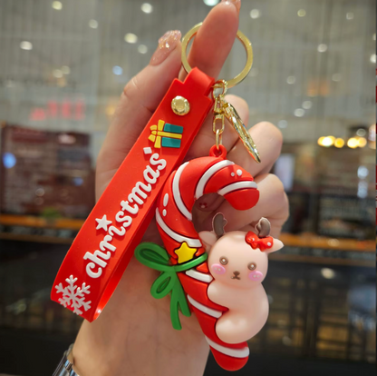 Christmas-themed keychain with candy cane design held by a hand.