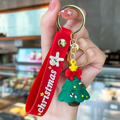 Red 'Christmas' keychain with a green tree charm held in a hand.