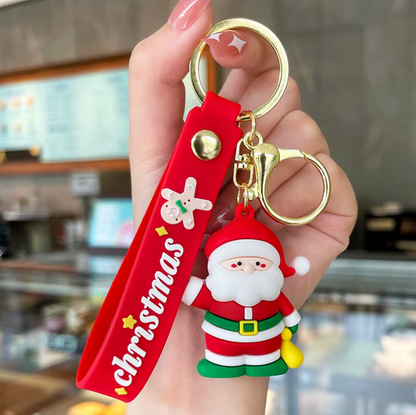 Keychain with Santa Claus figure and Christmas-themed tag held by a hand.