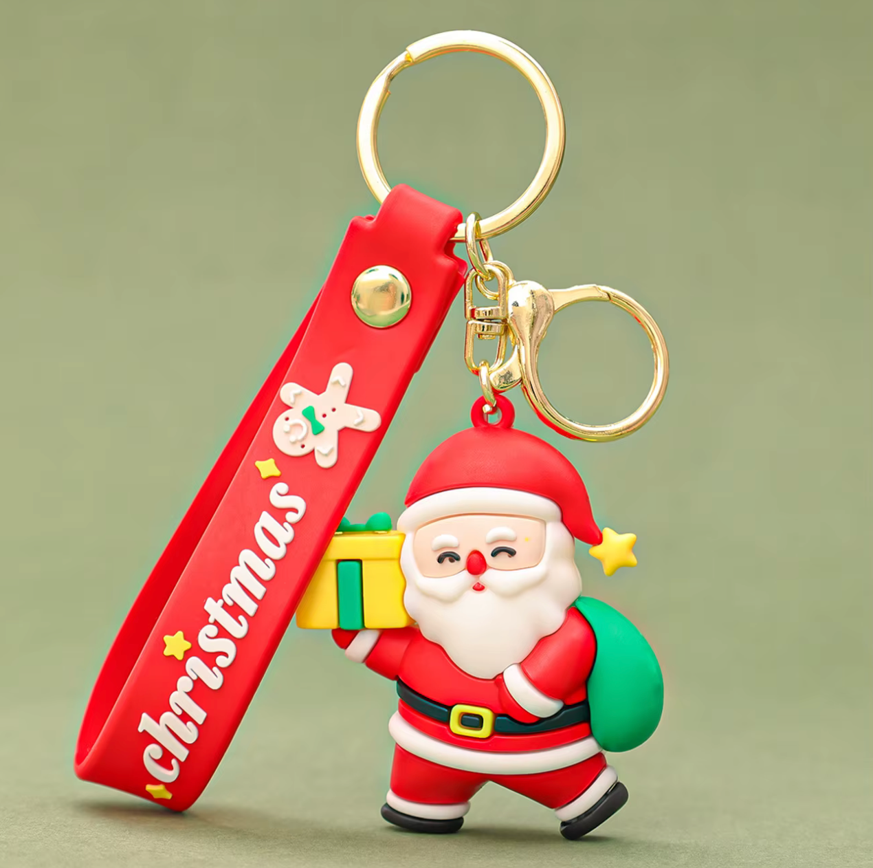 Keychain with Santa Claus figure and Christmas-themed strap on a green background
