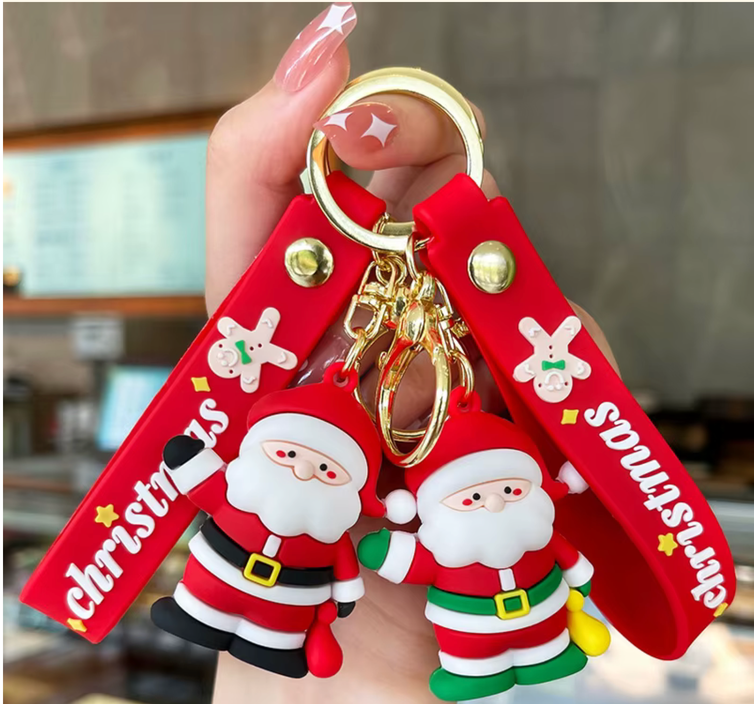 Keychain with Santa Claus figures and 'Christmas' text held by a hand.