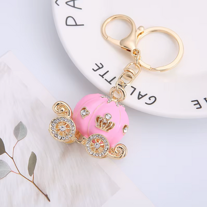 Pink car keychain with gold accents on a white surface