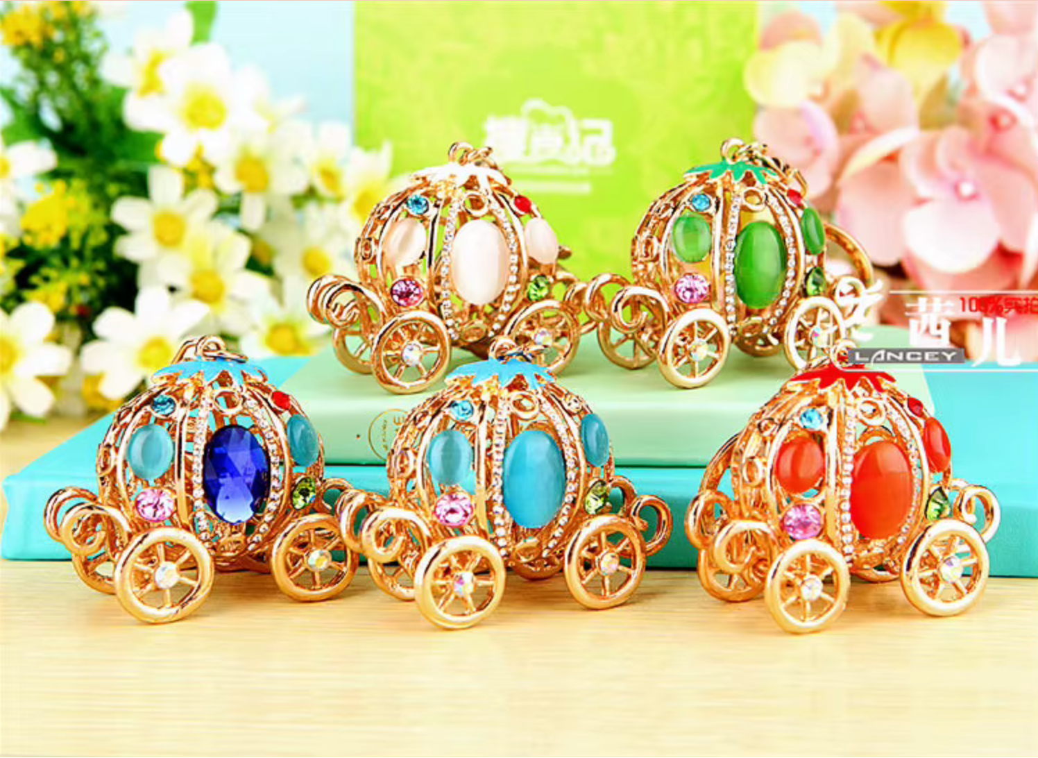 Colorful toy carriages with gemstones on a light surface with flowers in the background