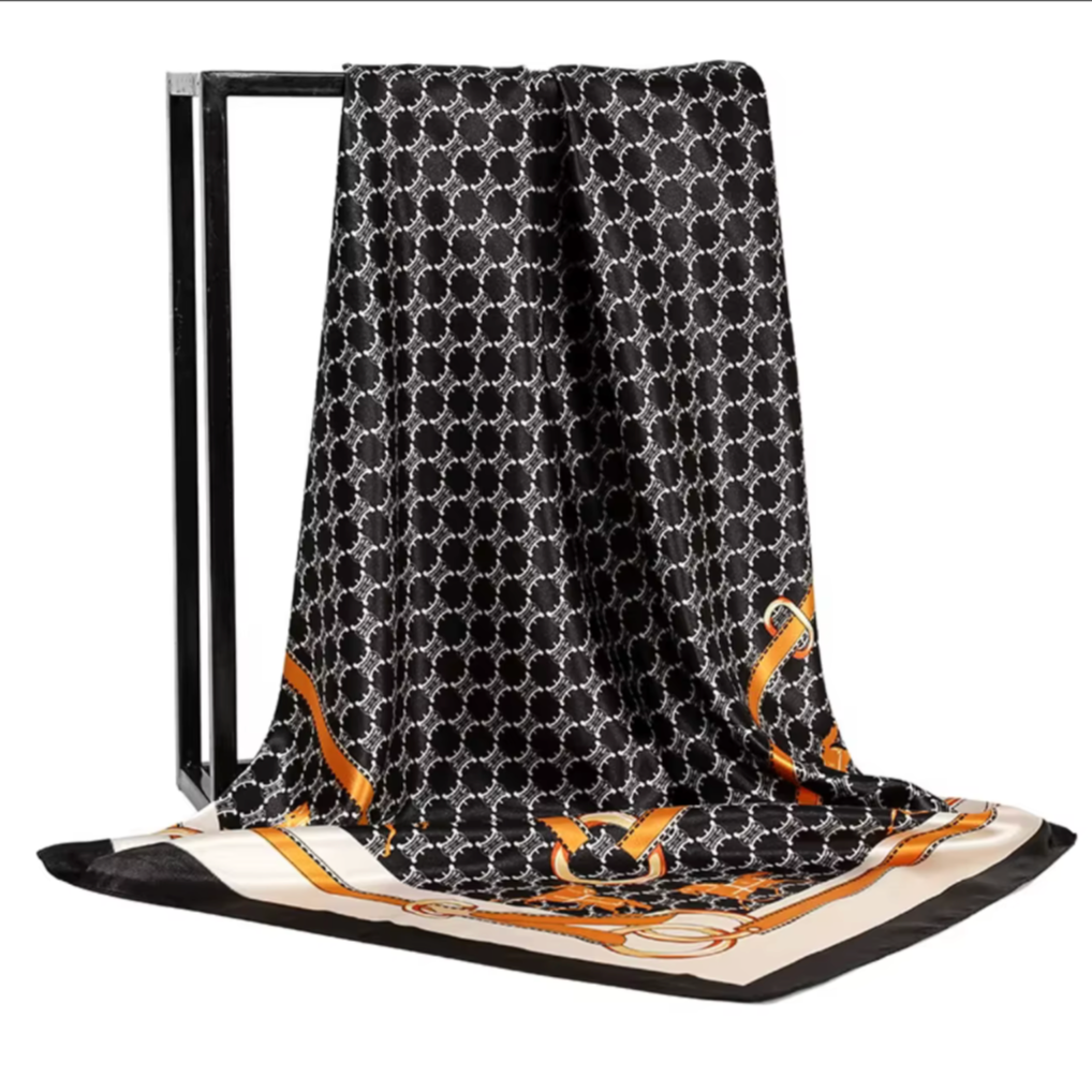 Black patterned scarf with gold accents on a white background