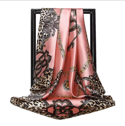 Scarf with leopard print and chain design on a pink background